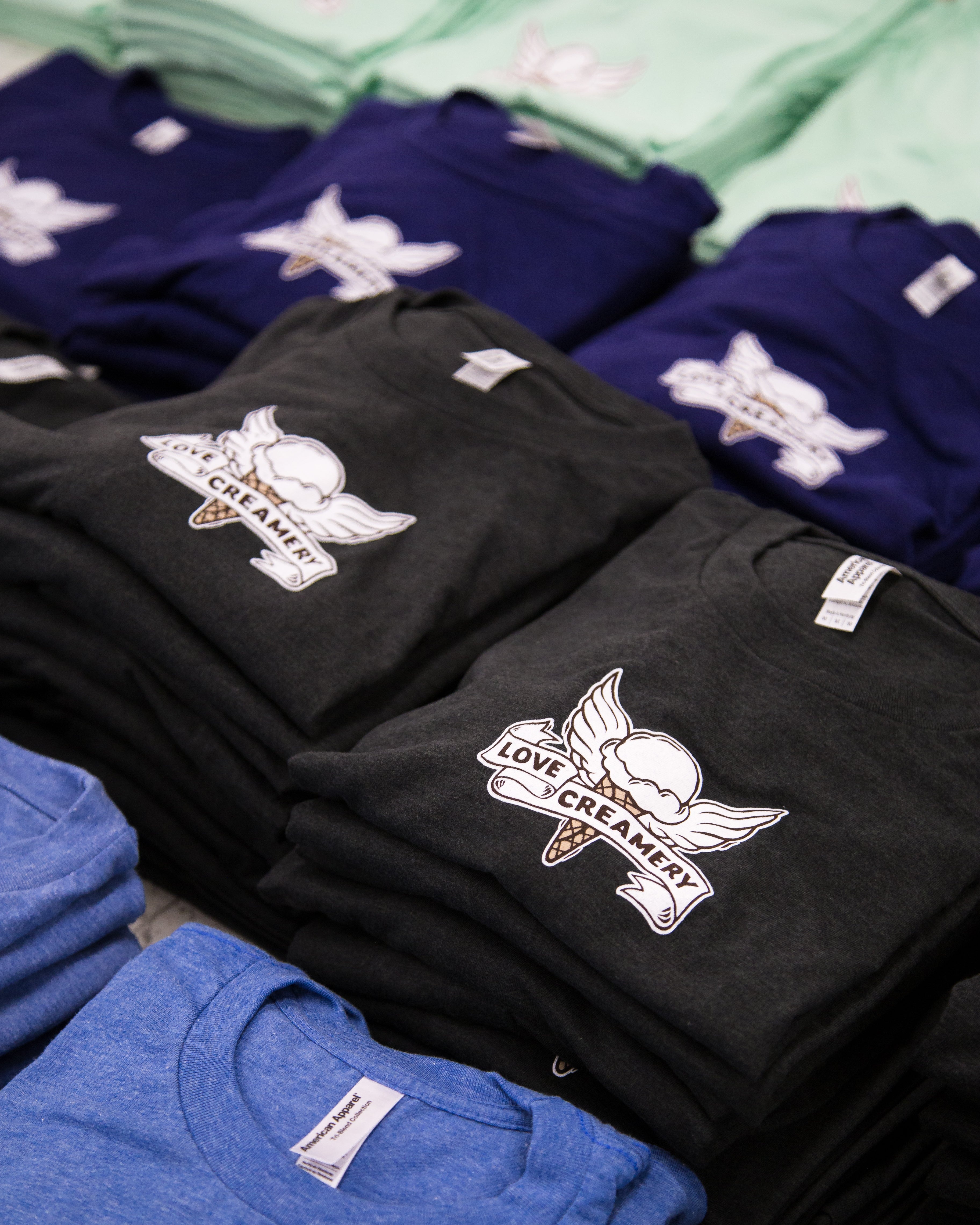 Folded T-shirts with Duluth's Love Creamery logo printed on them.